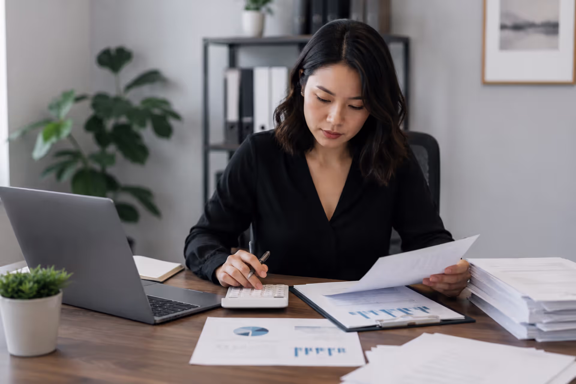 Small business owner managing tax documents, bookkeeping records, and financial reports in a modern office